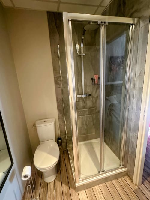 Salle de bains privée avec douche à l'italienne, toilettes et parquet au gîte Relais Du Destin à Vertrieu