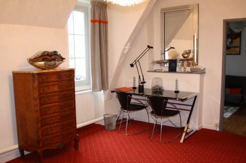 Élégant espace de travail Suite Intemporelle au Relais Du Destin, Vertrieu avec bureau, tapis bordeaux et commode en bois