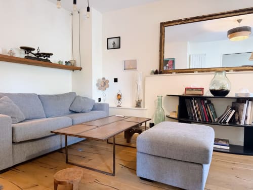 Séjour moderne de l'appartement Le Montaigne à la Maison ARLOÉ, La Rochelle, avec canapé bleu, table en bois et étagères