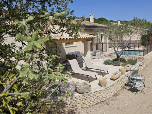 Terraza de lujo junto a la piscina de SARL MARIEMEO en Gordes con tumbonas, olivos y arquitectura villa mediterránea
