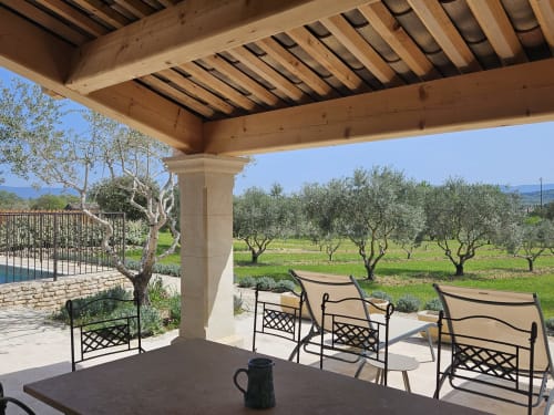 Terraza con pérgola con vistas a olivar en la propiedad de lujo de Gordes con zona de estar