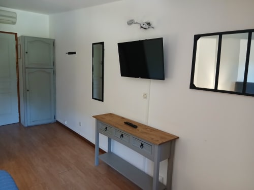 Chambre d'hôte Mas D Alivon à Arles avec télévision murale, console en bois et miroirs