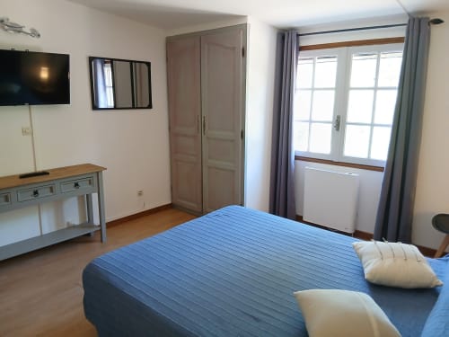 Spacieuse chambre double au Mas D Alivon, Arles avec vue sur le jardin, télévision moderne, literie bleue et lumière naturelle abondante