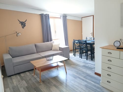 Studio familial au Mas d'Alivon à Arles avec canapé gris, table en bois et coin repas