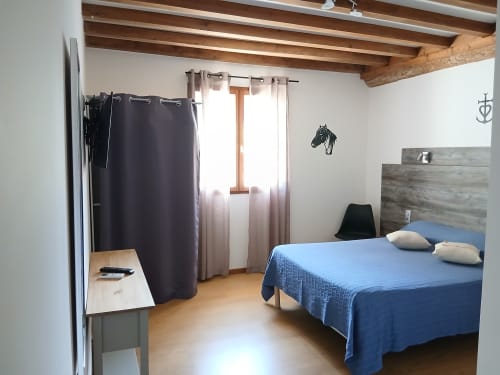 Chambre double au Mas d'Alivon B&B à Arles avec lit bleu, poutres en bois et équipements modernes