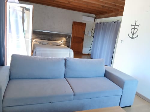 Canapé bleu clair dans une chambre standard Familiale du gîte Mas d'Alivon à Arles, France