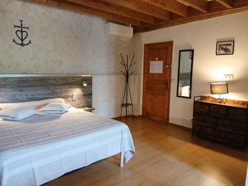Chambre spacieuse au Mas D Alivon à Arles : lit queen-size, tête de lit en bois, climatisation, TV écran plat, design moderne