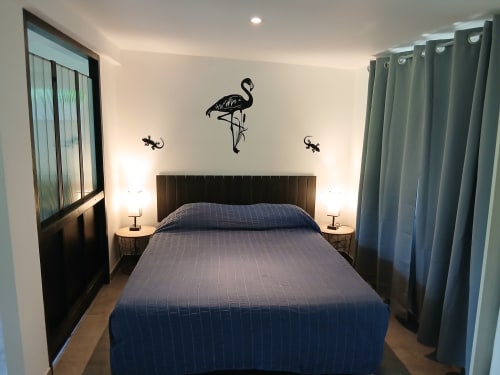 Chambre moderne au Mas D Alivon B&B à Arles avec décoration flamant rose, tête de lit foncée et rideaux bleus