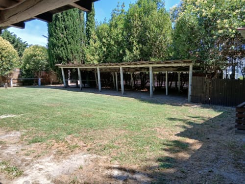 Structure de carport couverte avec volets en bois au Mas D'Alivon, un gîte à Arles, France, entourée de