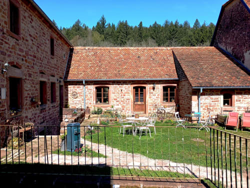 Cour du Paulusmühle B&B avec bâtiments en brique rouge, espace détente et forêt à Soucht, France