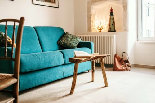 Divano turchese con tavolo in legno in luminosa camera in stile Ostuni presso la boutique hotel Pietra & Luce, Italia