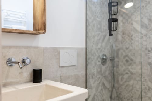 Bagno moderno nell'appartamento Pietra & Luce, Ostuni con lavabo a bacinella, doccia in marmo e specchio con cornice in legno