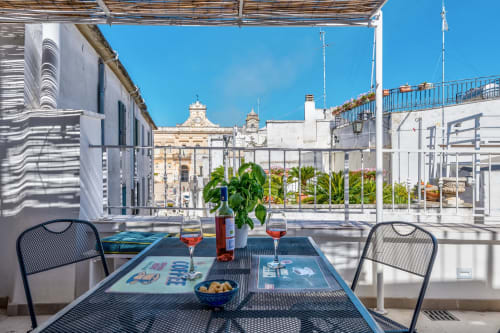 Terrazza sul tetto di Pietra & Luce a Ostuni con tavolo da pranzo, vista sul mare e architettura storica