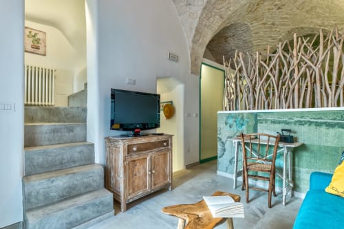Elegante interno di appartamento a Ostuni con TV, arredamento in legno, scale in pietra e terrazza con vista mare
