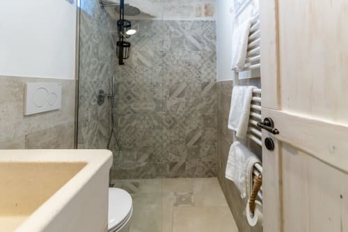 Bagno moderno a Pietra & Luce a Ostuni con doccia walk-in, scaldasalviette e finiture in marmo