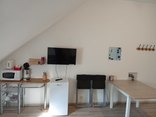 Kitchenette Le Relais de Poste avec micro-ondes, TV, chaises pliantes et coin repas aux Relais-Orbigny, Orbigny