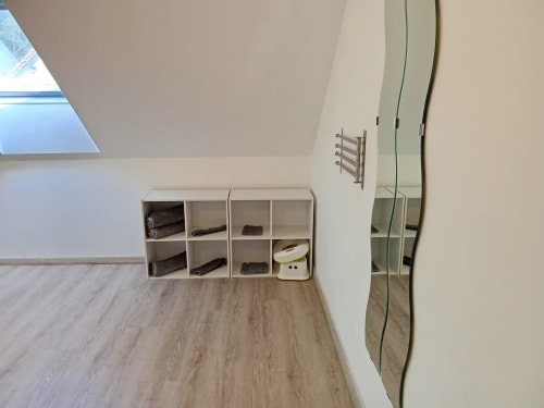 Chambre mansardée aux Relais-Orbigny avec cubes de rangement blancs, parquet et fenêtre de toit dans ce gîte d'Orbigny.