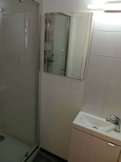 Salle de bains moderne au Relais de Jeanne aux Relais-Orbigny, avec carrelage blanc, douche vitrée et