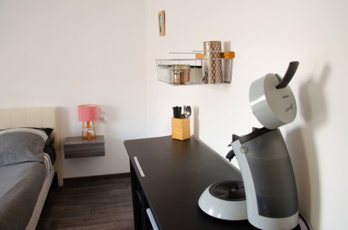 Chambre moderne aux Relais-Orbigny avec bureau, cafetière et rangements organisés à Orbigny, France