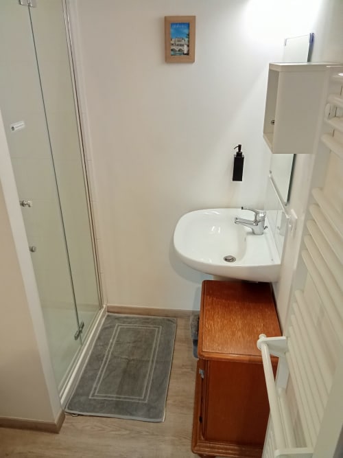 Salle de bains immaculée avec lavabo blanc, douche à l'italienne et vanité en bois, chambre Les Relais-Orbigny, Orbigny