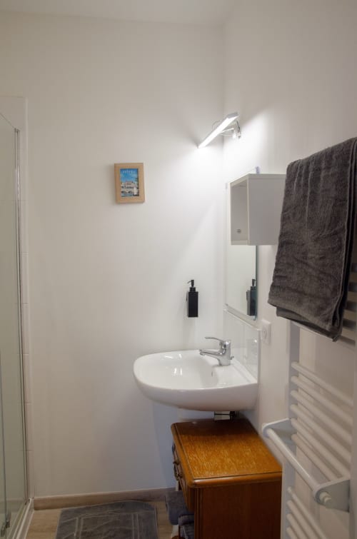 Salle de bain moderne au Relais de Louis des gîtes Les Relais-Orbigny, Orbigny, avec lavabo blanc rond et sèche-serviettes électrique