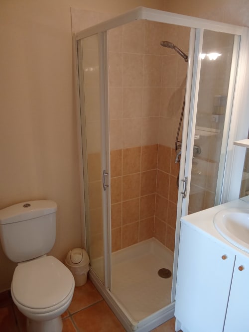Salle de bain moderne au Relais du Jardin des Relais-Orbigny : douche vitrée, vasque blanche et toilettes