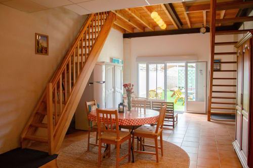 Salle à manger avec escalier en bois aux Relais-Orbigny, Orbigny, portes vitrées donnant sur le jardin