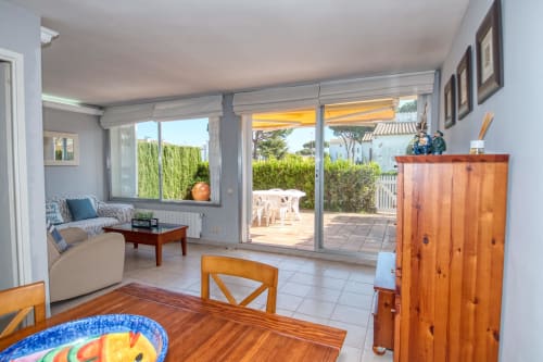 Sala lluminosa de l'hotel Finques Garcia Enrich a Palafrugell amb portes-finestres corredisses que s'obren a la terrassa