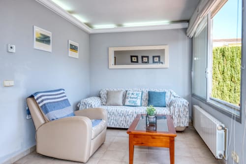 Sala d'estar il·luminada a l'hotel Finques Garcia Enrich a Palafrugell amb seients còmodes, decoració costanera i vistes al jardí