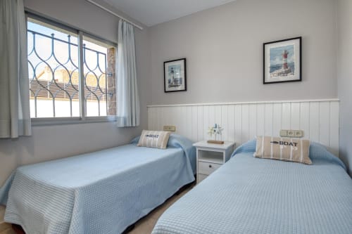 Habitació amb dos llits amb cobrellits enguixats blaus a l'hotel Finques Garcia Enrich de Palafrugell, Espanya