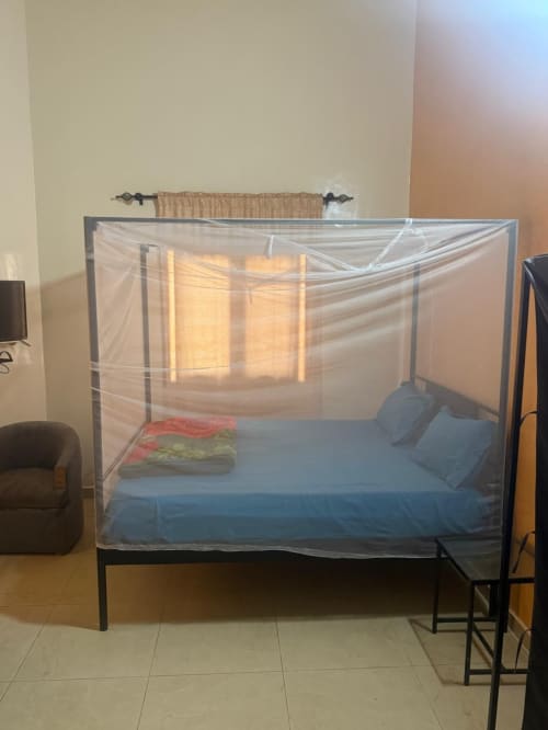 Lit à baldaquin avec parure bleue et moustiquaire dans la chambre Gorée 2 de l'hôtel Keur Medzo, Lac Rose, Sénégal