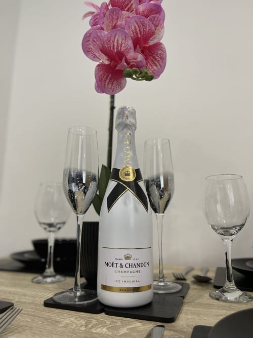 Moët & Chandon champagne bottle with pink orchid and champagne flutes at Empire Serviced Apartments, Leicester