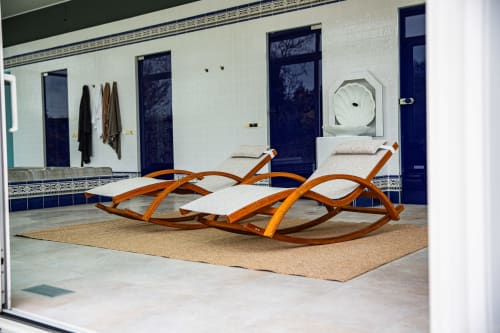 Deux chaises longues en bois courbes avec coussins crème sur tapis de liège à la Villa Bianca, boutique hôtel à Mortroux Dalhem, Belgique