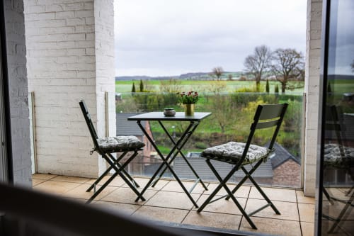 Terrasse extérieure de la Villa Bianca avec vue sur le jardin et le paysage de la campagne à Mortroux Dalhem, Belgique