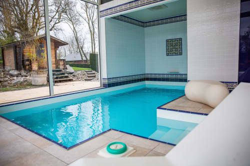 Piscine intérieure de la Villa Bianca avec eau turquoise, espace détente et équipements spa à Mortroux Dalhem