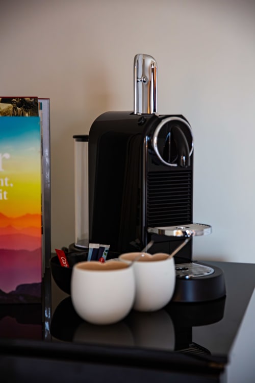 Machine à café Nespresso avec deux tasses blanches dans la chambre de luxe Villa Bianca à Mortroux Dalhem