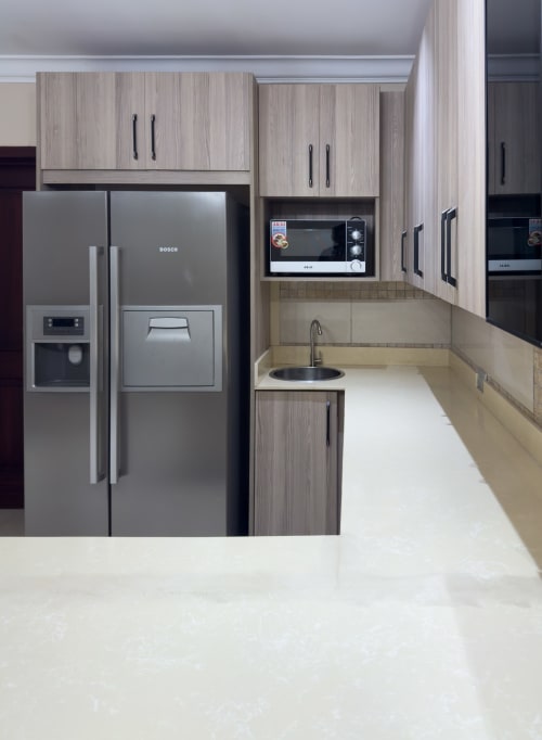 Modern kitchen in Capella Unit 4 at Cozy Apartments Ghana featuring Bosch stainless steel appliances, light wood cabinetry,