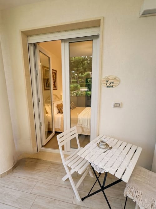 Camera Alba room at B&B Alba in Polignano a Mare with bedroom view through glass doors and small terrace table