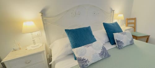 Cozy bedroom at B&B Alba in Polignano a Mare with decorative pillows and bedside lamps