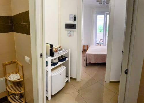 Camera Bea at B&B Alba in Polignano a Mare: hallway with kitchenette, bedroom and garden view