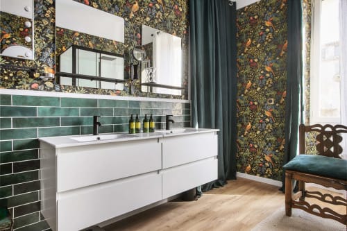 Salle de bains moderne de l'appartement L'ENVOL à l'Alombre B&B, Lectoure, avec papier peint fleuri, carrelage métro vert, lavabo blanc et