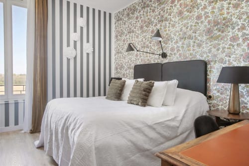Chambre moderne de l'Alombre B&B à Lectoure avec murs à rayures, papier peint fleuri et vue sur les montagnes