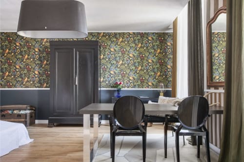L'appartement L'Aparté à l'Alombre B&B de Lectoure avec papier peint fleuri, chaises noires modernes et mobilier élégant