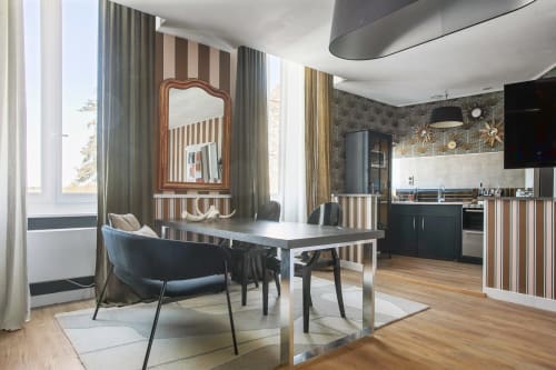 Cuisine-séjour moderne de l'appartement L'APARTÉ au Alombre B&B, Lectoure, avec mobilier rayé et vue sur les montagnes