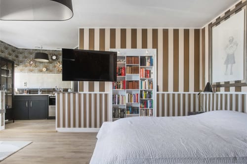 L'appartement L'Aparté à Alombre B&B à Lectoure offre des murs rayés, des rambardes blanches, une TV murale, une bibliothèque et un style moderne