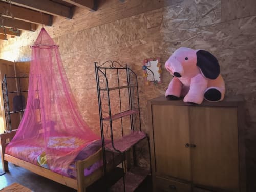 Pink canopy bed with decorative elephant plush in shared bedroom at Le Lama Zébré BnB, Penmarch