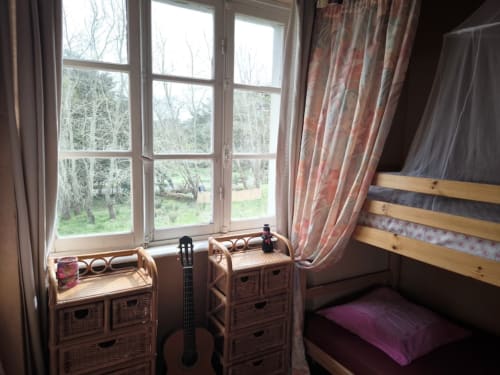 Bright dorm bedroom with wooden bunk beds, garden view windows, and shared amenities at Le Lama Zébré B&B in Penmarch