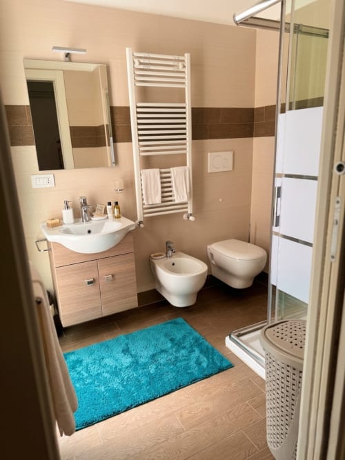 Bagno moderno nel B&B Alba a Polignano a Mare con lavandino, bidet, wc, scaldasalviette e zona doccia