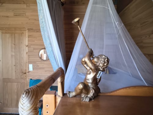 Bronze cherub statue with canopy bed at Le Lama Zébré B&B in Penmarch, France
