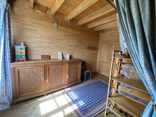 Shared bedroom at Le Lama Zébré in Penmarch with wooden beams, beds, and patterned rug